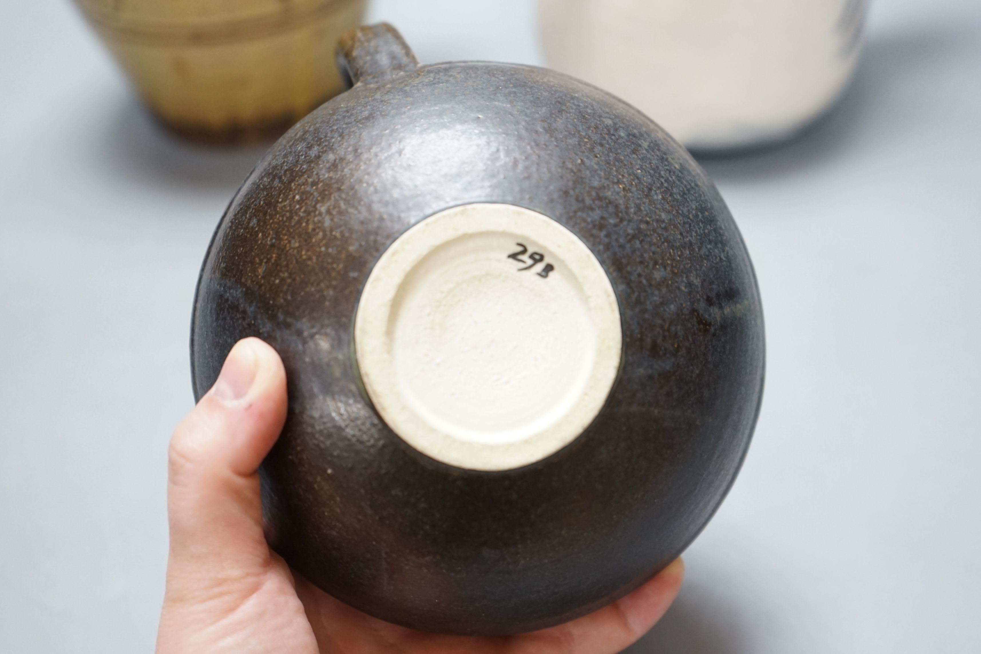 British studio pottery; a Jane Sawyer coffee pot and cover, Danlami Aliyu, for Wenford Bridge Pottery, pale green glazed stone were covered jug, and a black glazed white stoneware teapot, tallest 25cm, (3)